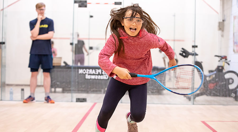 A girl running on a squash court