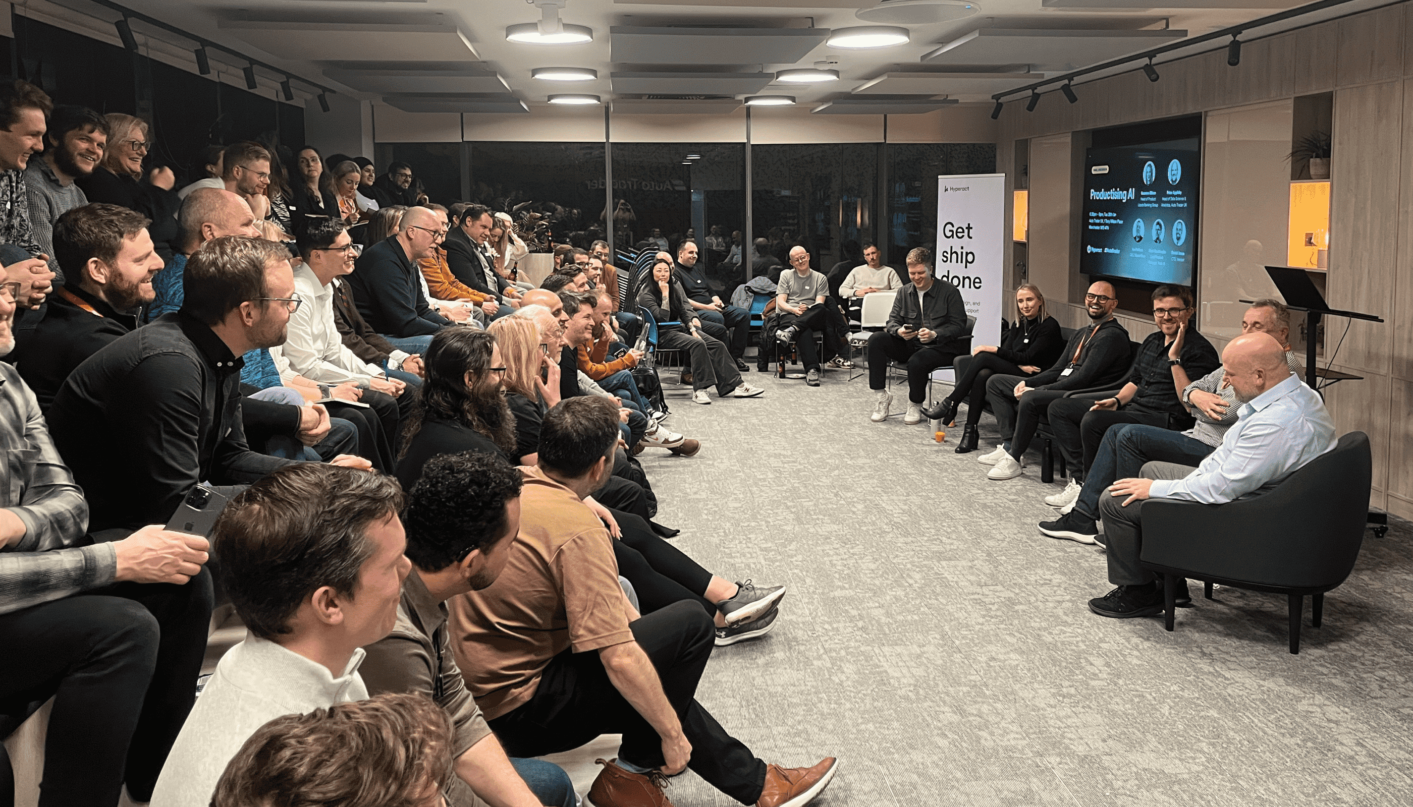 A picture showing a panel discussion in a busy room